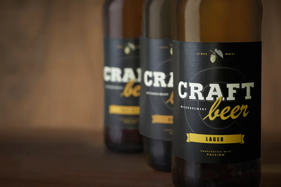 Botellas de cerveza artesana con etiqueta negra y letras doradas